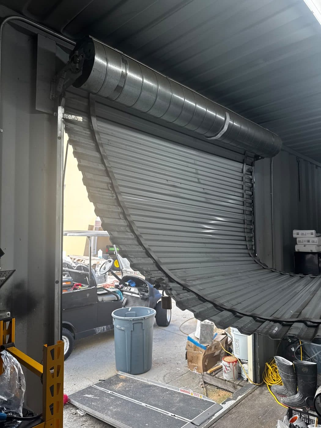 Commercial rolling steel door repair — before